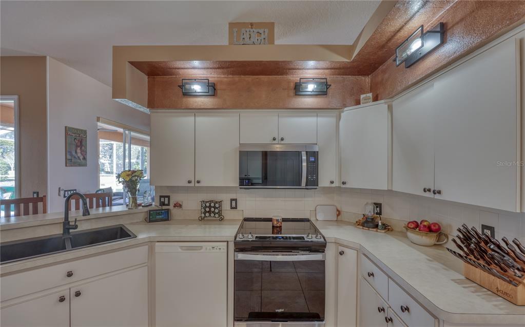 3473 Conifer Loop Spring Hill, FL 34609 - Photo 9 of 33 a kitchen with a sink stove and cabinets