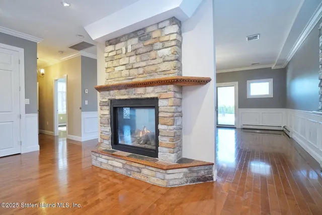 a view of a hallway with wooden floor and a fireplace