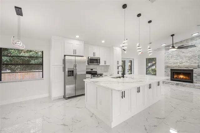 a open kitchen with stainless steel appliances granite countertop a stove and refrigerator