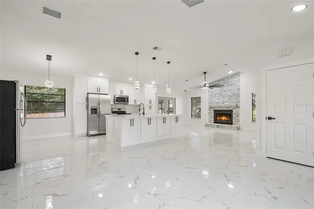 a hall with kitchen island a sink appliances and a counter space