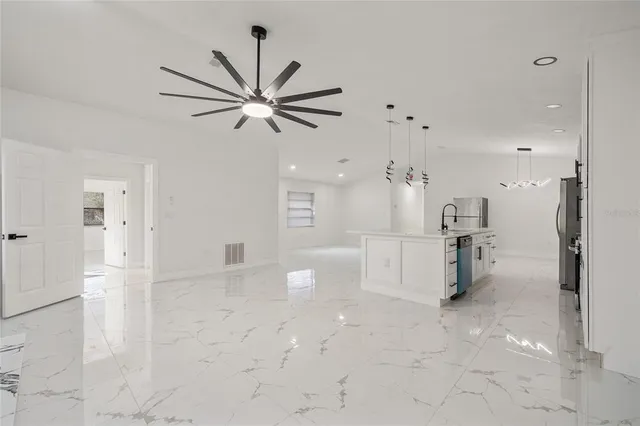 an empty room with windows fireplace and fans