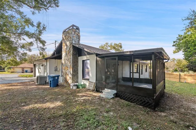 a view of a house with a yard and large tree