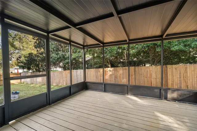 a view of empty room with wooden floor and iron fence