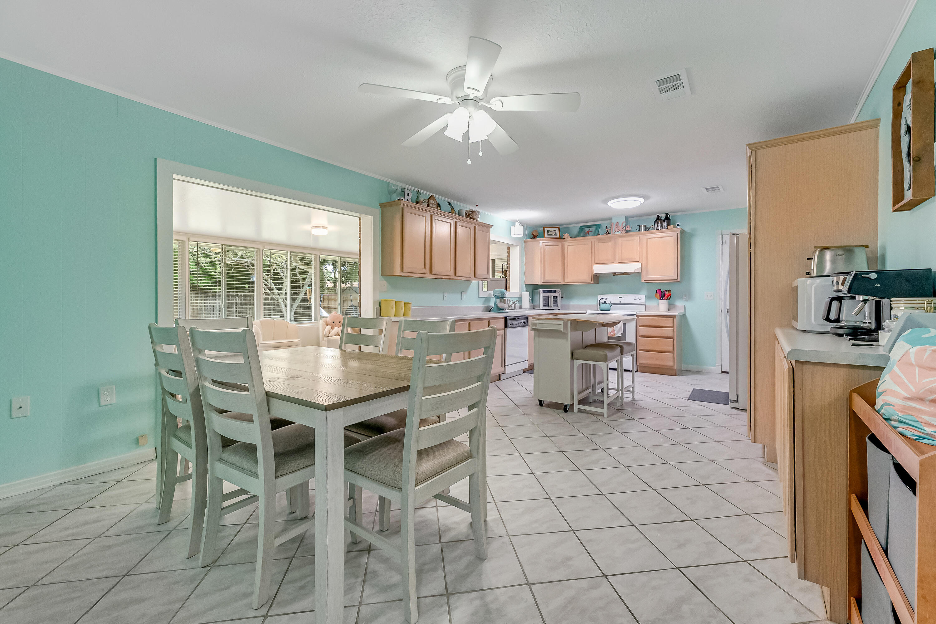1811 Rattan Palm Drive Niceville, FL 32578 - Photo 18 of 57 a kitchen with a dining table chairs and white appliances