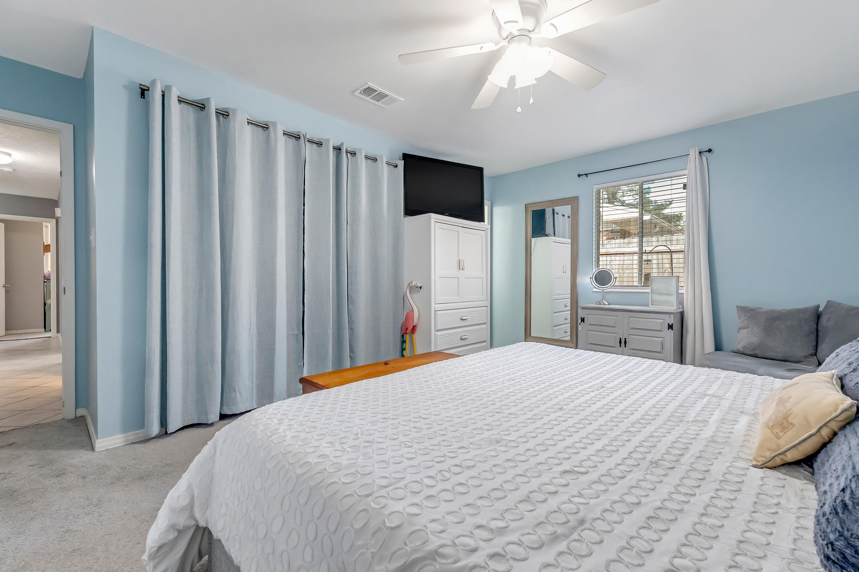 1811 Rattan Palm Drive Niceville, FL 32578 - Photo 29 of 57 a bedroom with a large bed and a chandelier