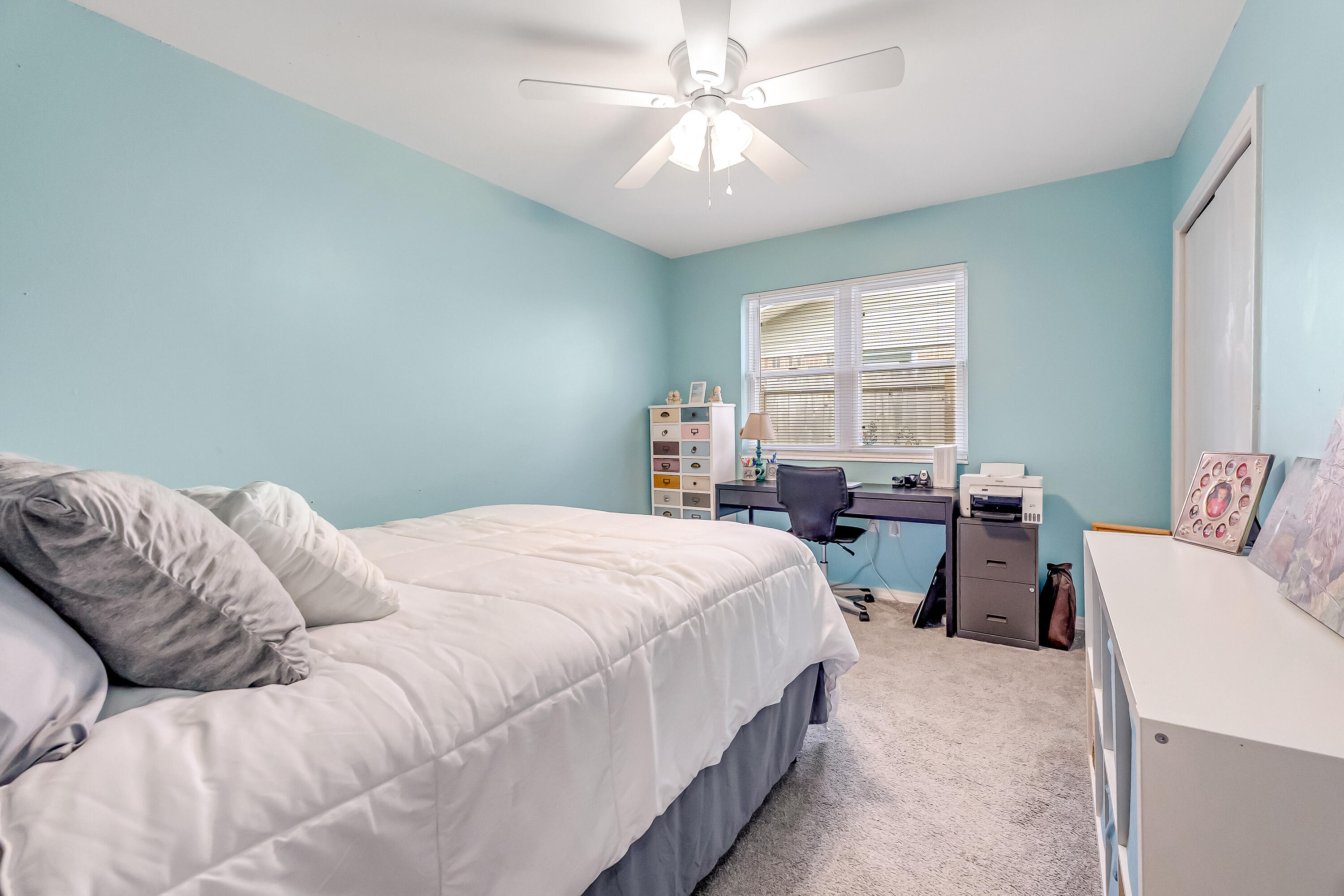 1811 Rattan Palm Drive Niceville, FL 32578 - Photo 40 of 57 a bedroom with a bed and a chandelier