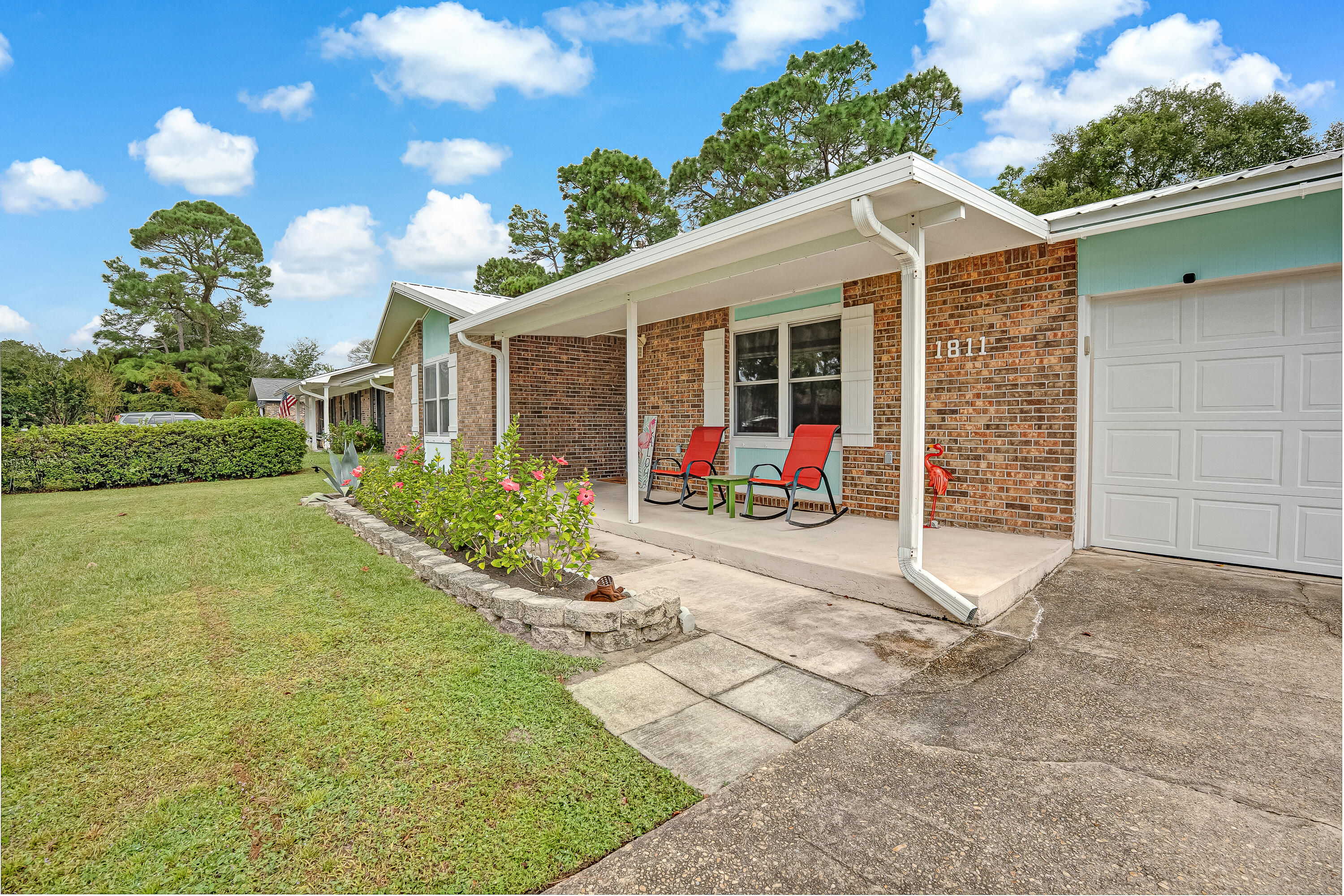 1811 Rattan Palm Drive Niceville, FL 32578 - Photo 55 of 57 a front view of a house with a yard and potted plants