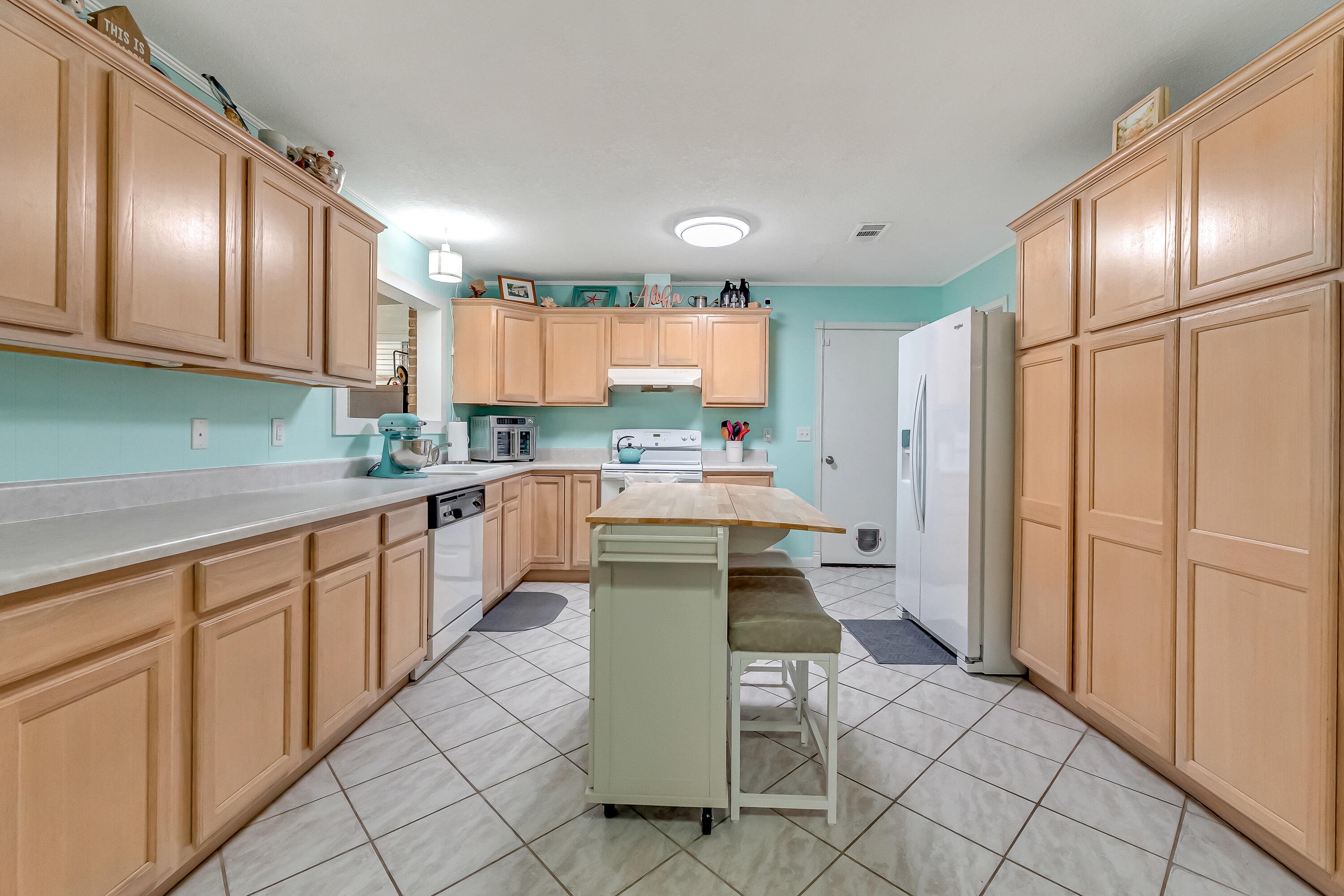 1811 Rattan Palm Drive Niceville, FL 32578 - Photo 8 of 57 a kitchen with stainless steel appliances kitchen island granite countertop a refrigerator oven a sink dishwasher and white cabinets with wooden floors
