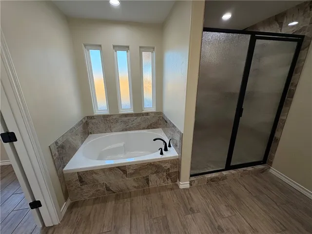 a bathroom with a tub a sink and a window