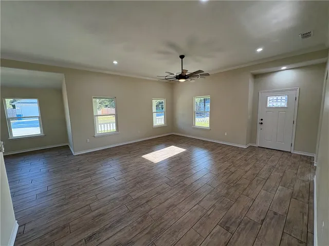 a view of empty room with window and wooden floor
