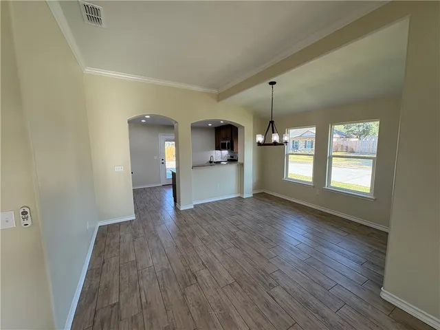 a view of a room with wooden floor and a window