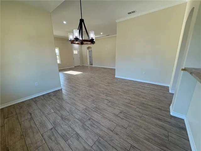 a view of a room with wooden floor ceiling fan and window