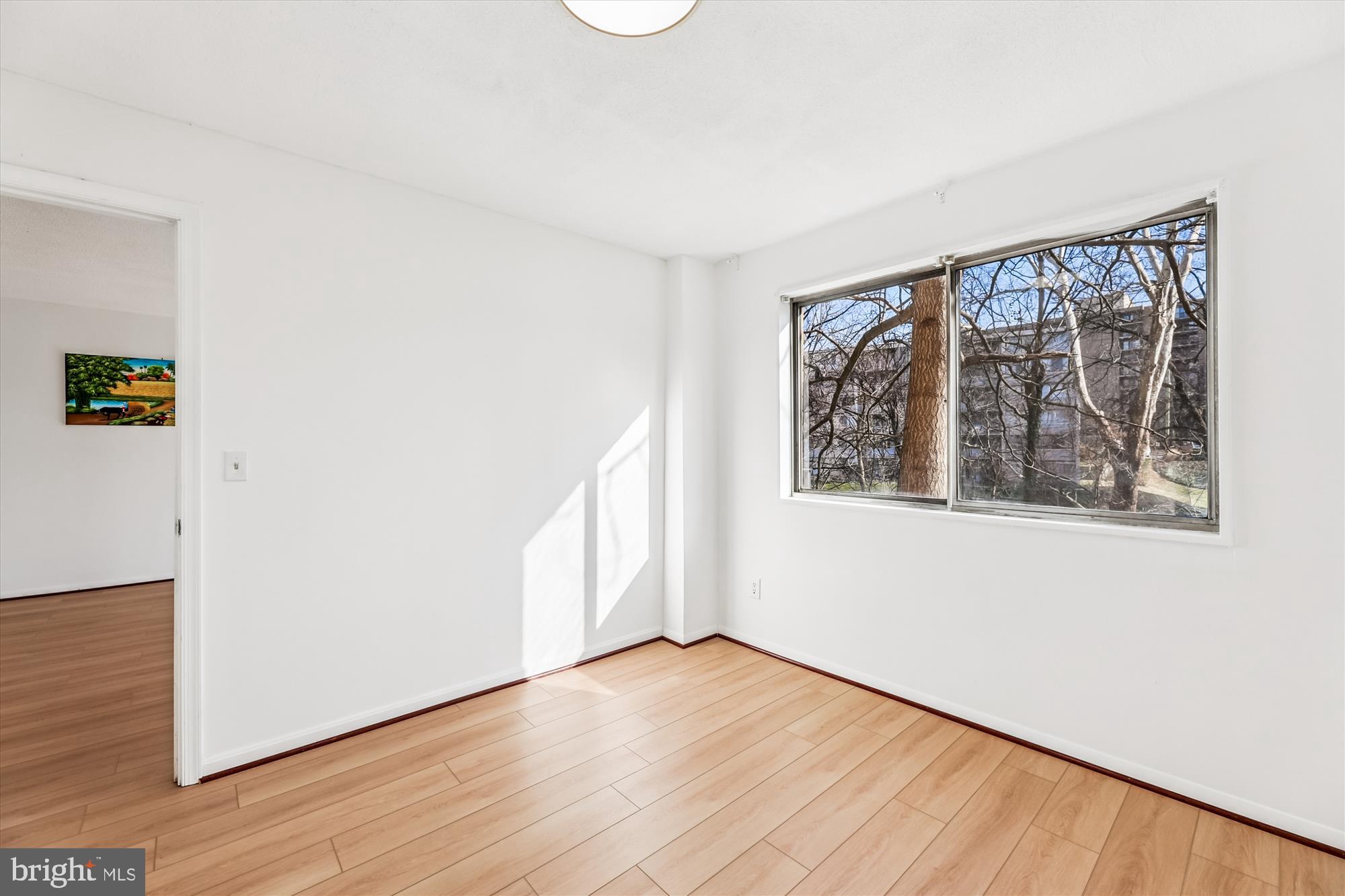 1836 Metzerott Road, Unit T3 Hyattsville, MD 20783 - Photo 14 of 28 a view of an empty room with wooden floor and a window