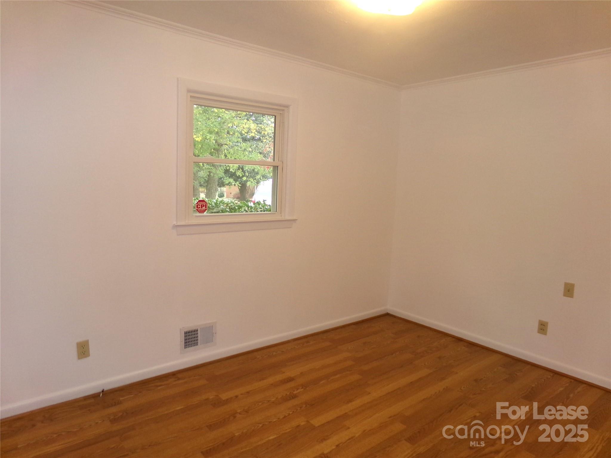 801 Anderson Road Albemarle, NC 28001 - Photo 12 of 23 an empty room with wooden floor and windows