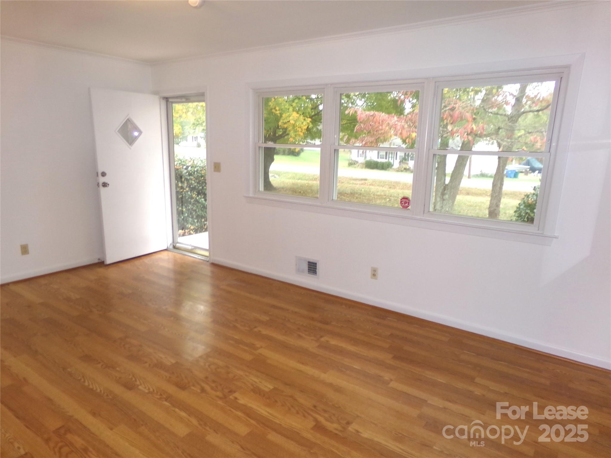 801 Anderson Road Albemarle, NC 28001 - Photo 3 of 23 a view of an empty room with wooden floor and a window