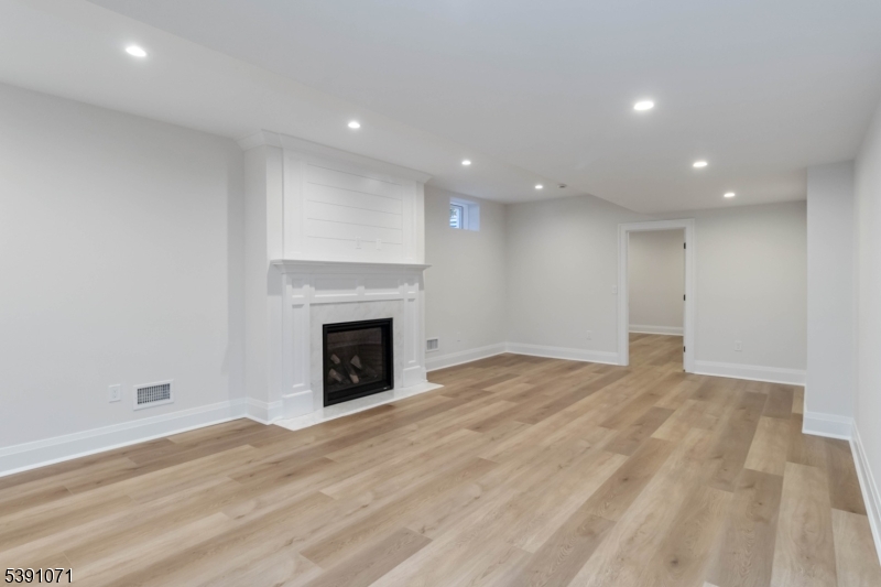 2 Whitman Drive Chatham, NJ 07928 - Photo 42 of 50 a view of empty room with wooden floor and fireplace