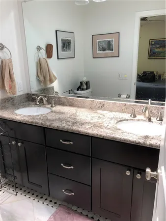 a bathroom with a granite countertop sink and a mirror