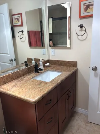 a bathroom with a granite countertop sink and a mirror