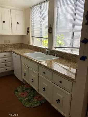 a kitchen with granite countertop cabinets appliances and a window