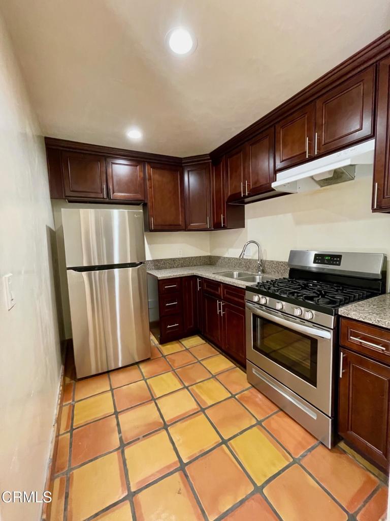 211 Fox Street Ojai, CA 93023 - Photo 22 of 33 a kitchen with granite countertop a refrigerator and a stove top oven