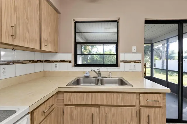 a kitchen with a sink cabinets and window