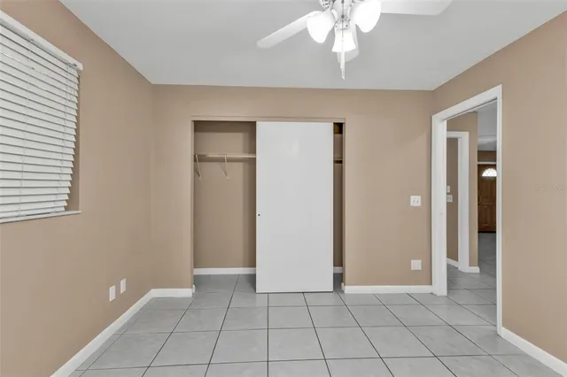 a view of an empty room with window chandelier fan
