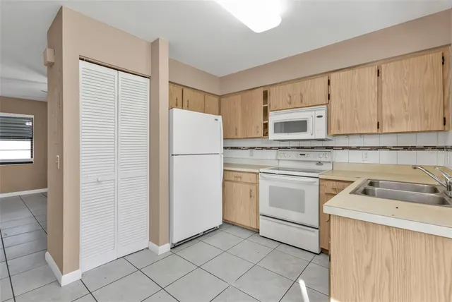 a kitchen with white cabinets and white appliances