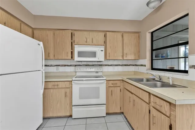 a kitchen with white cabinets sink and white appliances