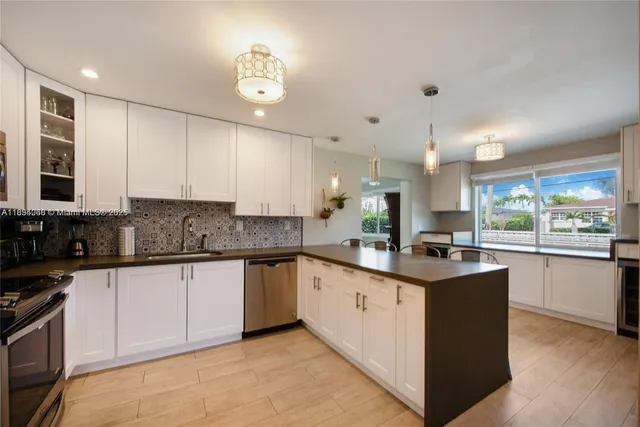 a kitchen with granite countertop a sink a counter top space cabinets and stainless steel appliances