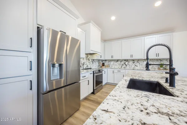 a kitchen with a refrigerator sink and cabinets
