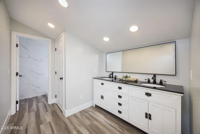 a bathroom with double vanity sink and mirror