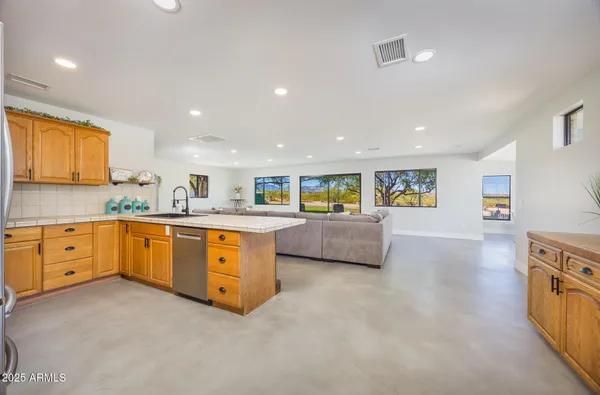 a living room with furniture and a view of kitchen