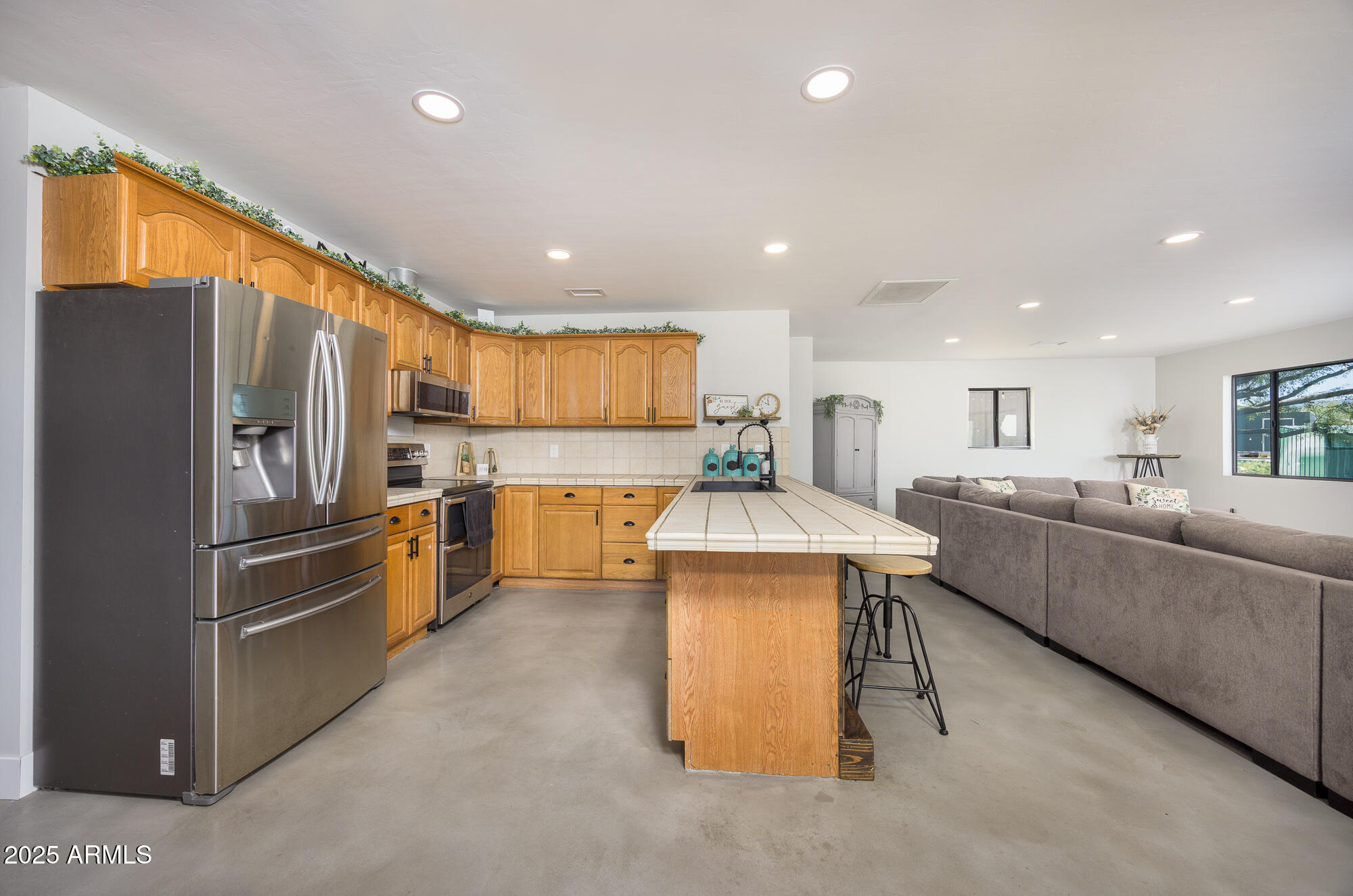 1302 West Coyote Trail Benson, AZ 85602 - Photo 35 of 57 a kitchen with stainless steel appliances kitchen island granite countertop a refrigerator and a stove top oven