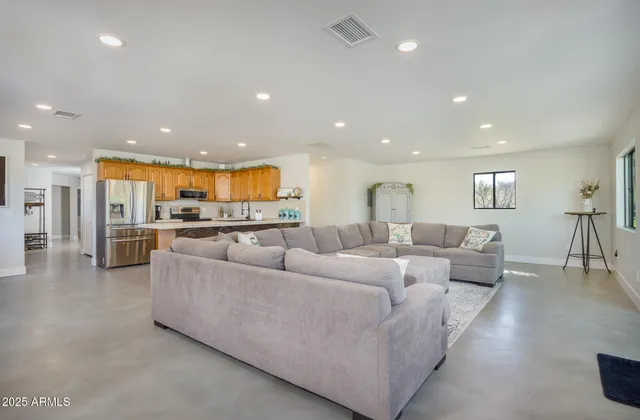 a living room with furniture and a view of kitchen