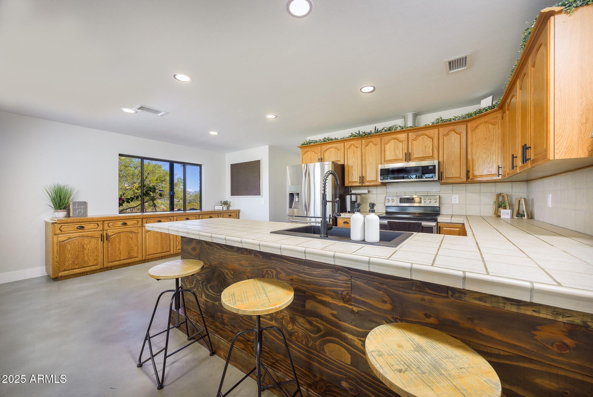 1302 West Coyote Trail Benson, AZ 85602 - Photo 39 of 57 a large kitchen with kitchen island a large counter top space a sink stainless steel appliances and cabinets
