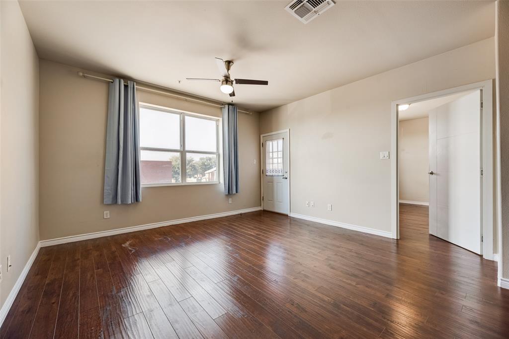 1100 West Trinity Mills Road, Unit 2040 Carrollton, TX 75006 - Photo 9 of 21 an empty room with wooden floor chandelier and windows
