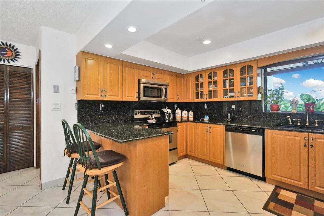 17020 Southwest 62nd Street Southwest Ranches, FL 33331 - Photo 25 of 44 a kitchen with stainless steel appliances granite countertop a stove a sink and a microwave