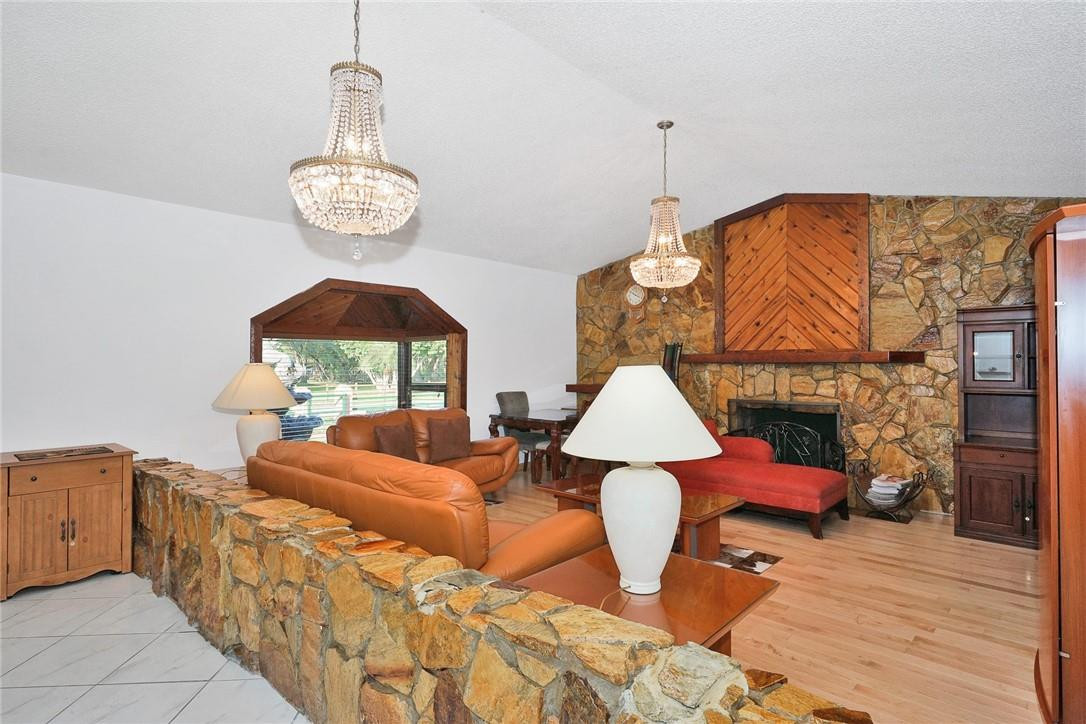 17020 Southwest 62nd Street Southwest Ranches, FL 33331 - Photo 28 of 44 a living room with furniture a chandelier and a wooden floor