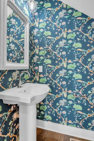 a view of empty room with wooden floor and kitchen