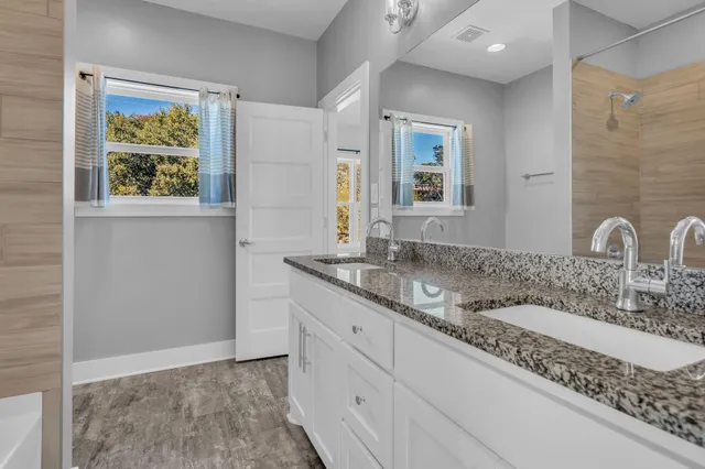 a bathroom with a granite countertop sink and a mirror