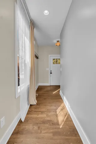 a view of a hallway with wooden floor and staircase