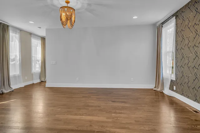 an empty room with wooden floor and window