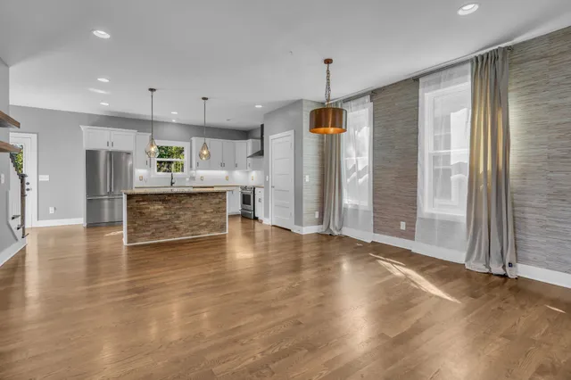 a kitchen with stainless steel appliances kitchen island hardwood floor sink and stove