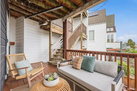 a balcony with furniture and a potted plant