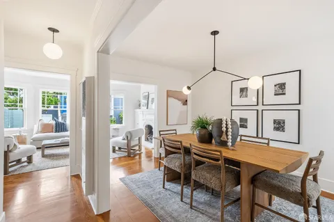 a dining room with furniture wooden floor a rug and a chandelier