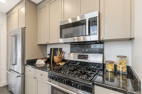 a kitchen with stainless steel appliances granite countertop a stove microwave and cabinets