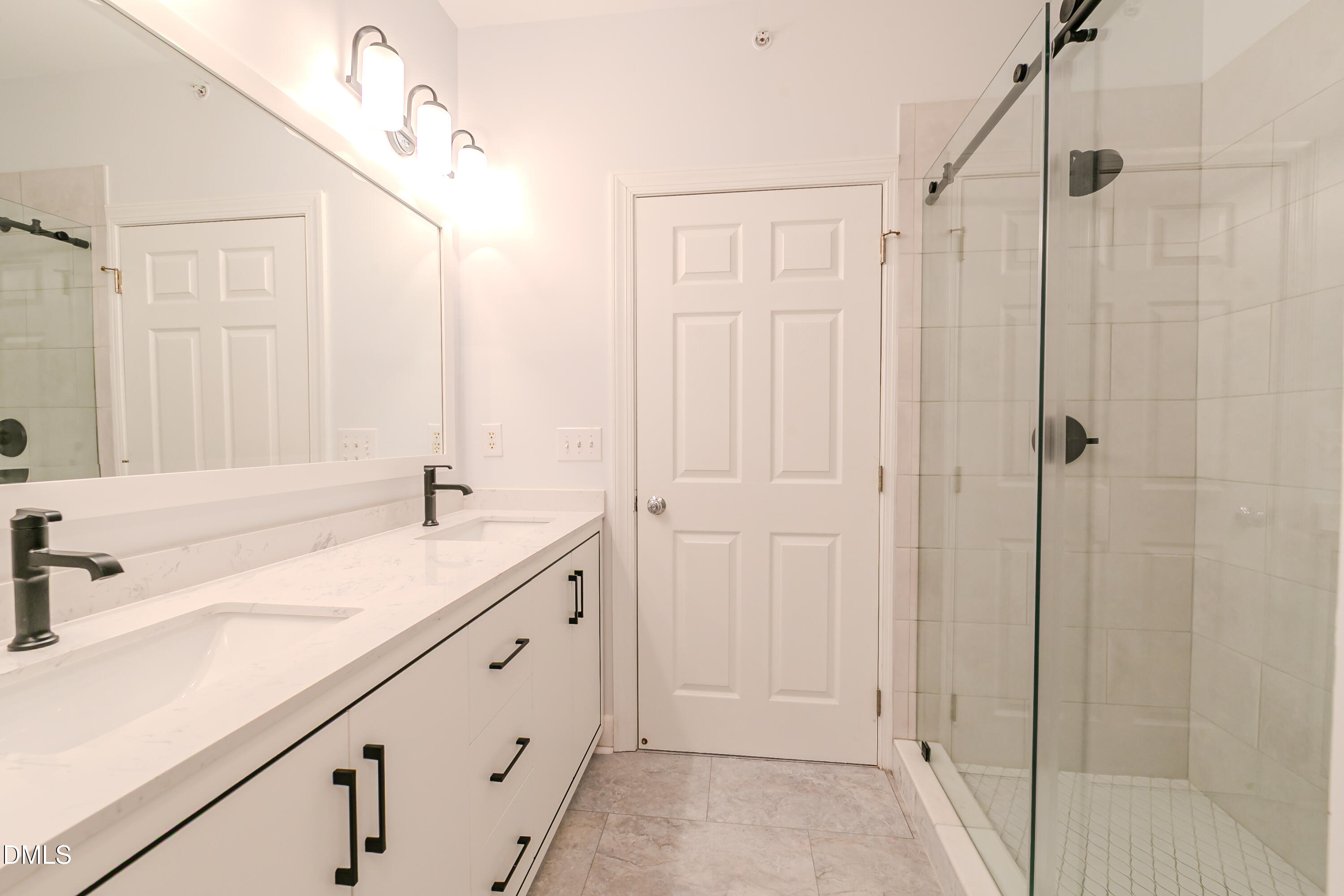 116 Northbrook Drive, Unit 305 Raleigh, NC 27609 - Photo 35 of 43 a bathroom with a double vanity sink a mirror and a shower