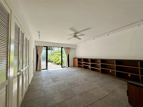 a view of an empty room with windows & cabinet