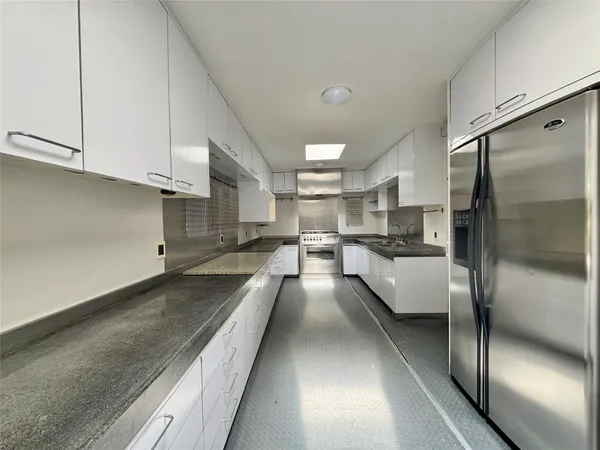 a large kitchen with kitchen island a large window