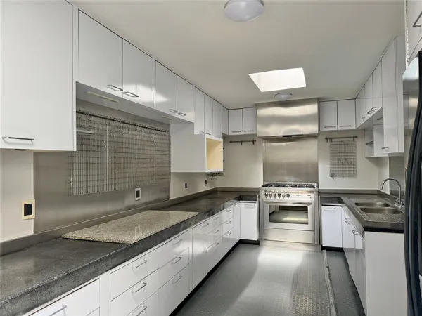 a kitchen with stainless steel appliances granite countertop a sink and stove